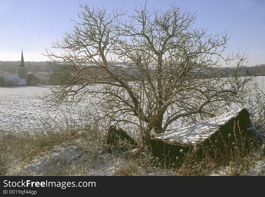 A hut in the snow with church in background. A hut in the snow with church in background.