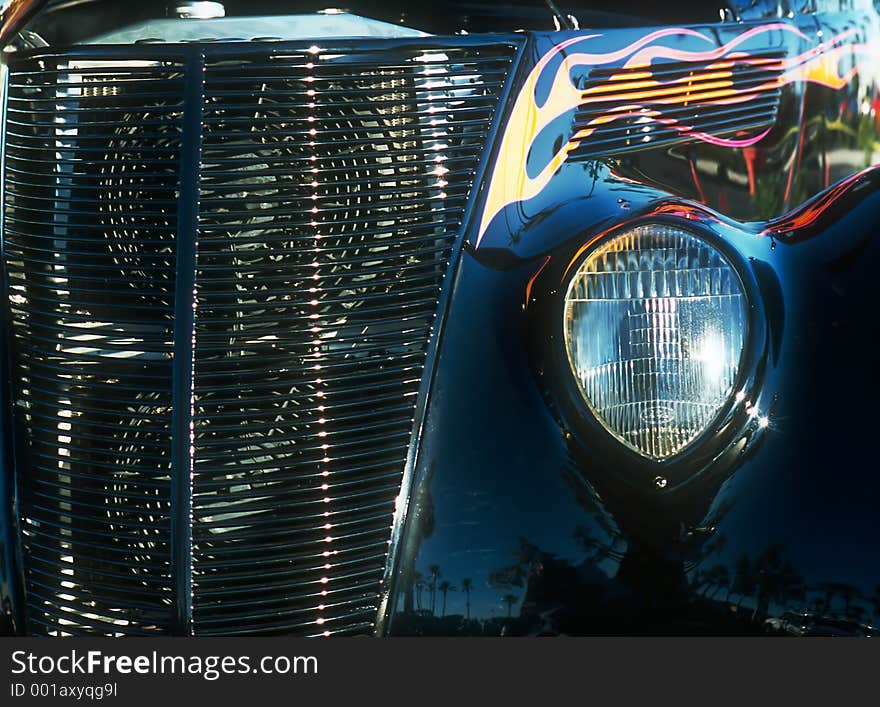 Car - roadster - view of front headlight and front grille - flame paint hightlights. Car - roadster - view of front headlight and front grille - flame paint hightlights