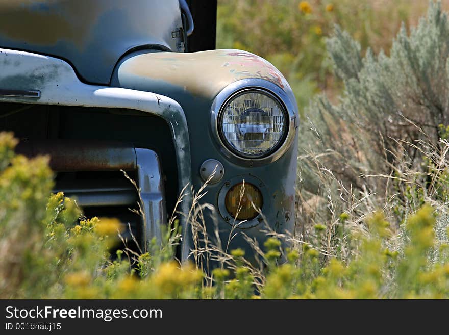 Vintage farmtruck abandoned in a field - focus on headlight. Vintage farmtruck abandoned in a field - focus on headlight