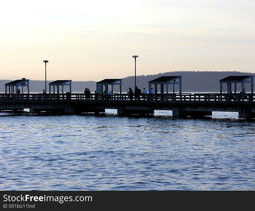 Part of a public fishing pier on the Tacoma Waterfront, silhouetted against an evening sky.