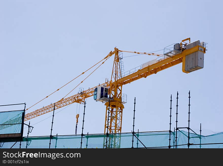 Construction crane on building site with scafolding in foreground