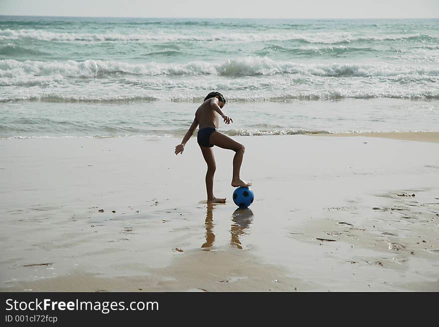 Young boy playing ball on the beach. Young boy playing ball on the beach