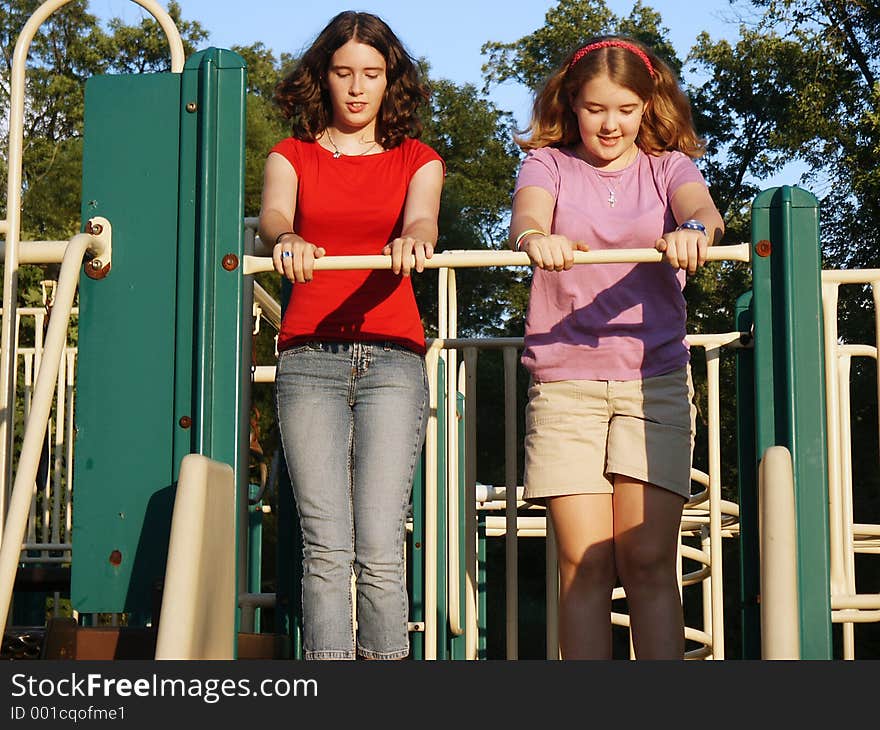 Teen sisters standing at the top of the slides. Teen sisters standing at the top of the slides