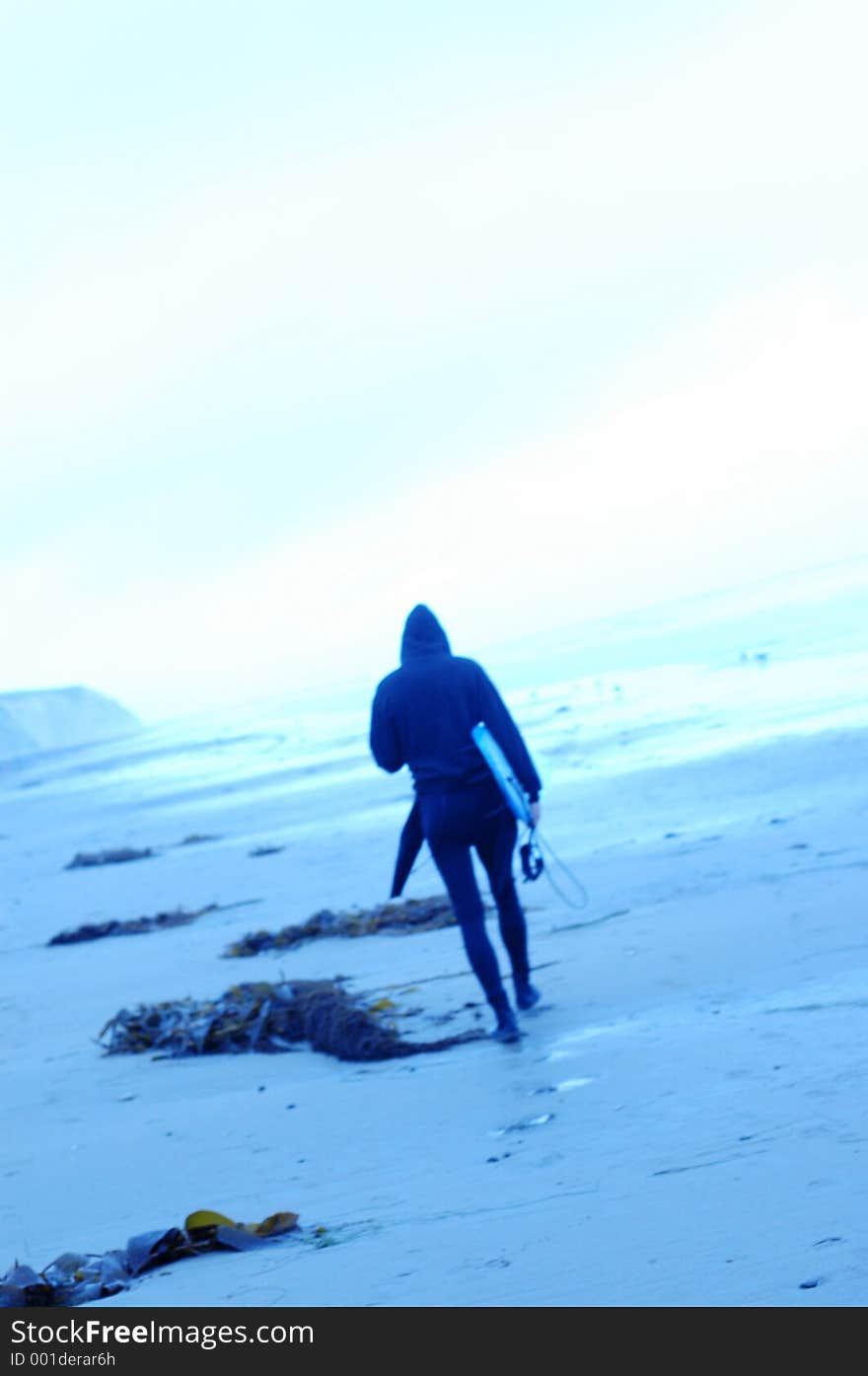 Soft focus blue toned images of surfers. Single surfer walking. Soft focus blue toned images of surfers. Single surfer walking.