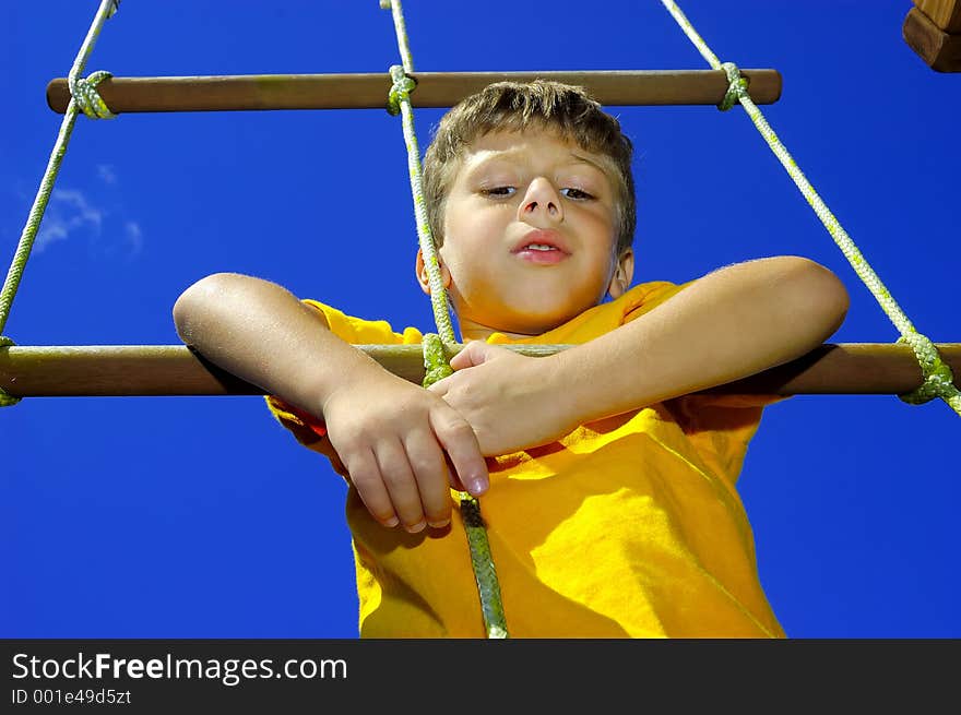 Young Boy Climbing a Rope Ladder. Young Boy Climbing a Rope Ladder.