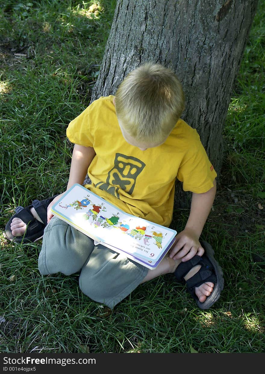 Five year old boy reading a book. Five year old boy reading a book