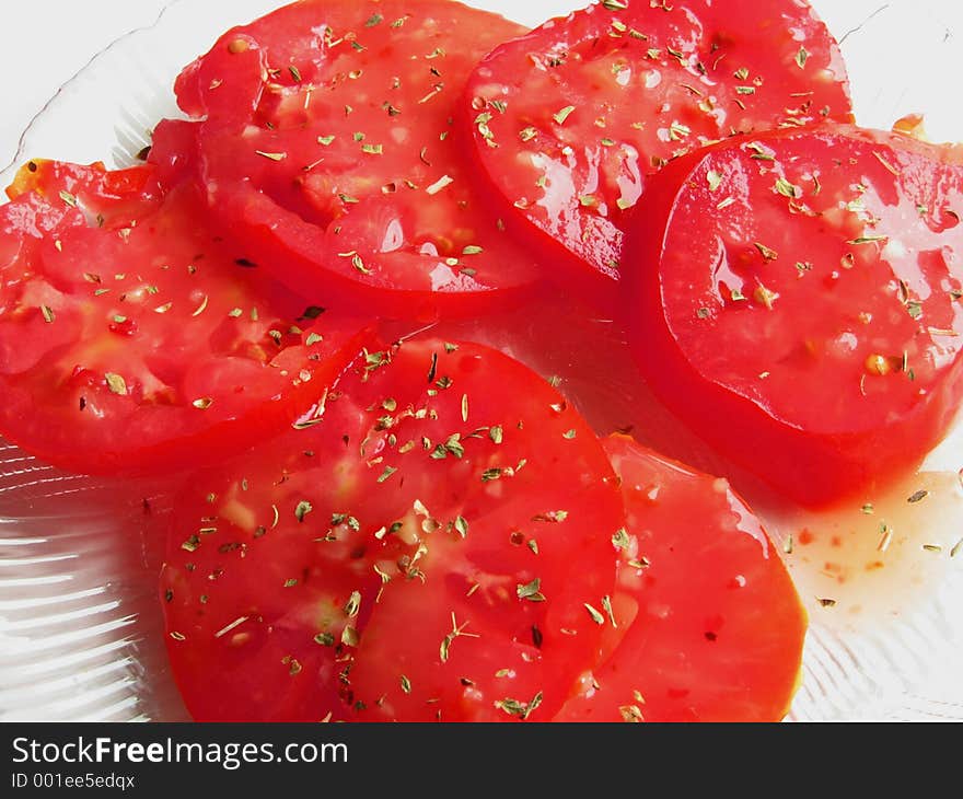 Sliced tomatoes with dressing, garnished with basil