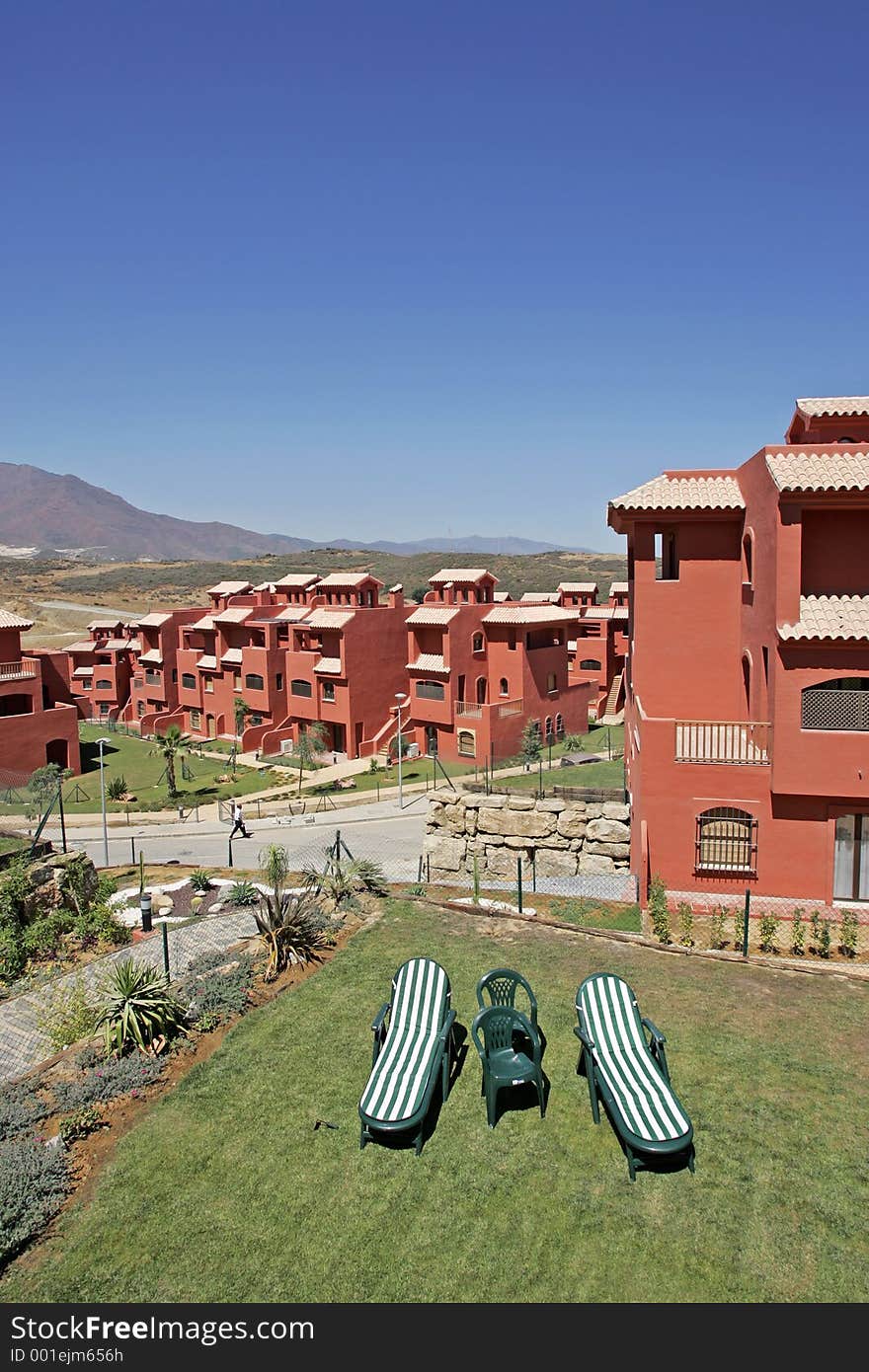 Sun loungers in garden on hot sunny day on new development in Spain