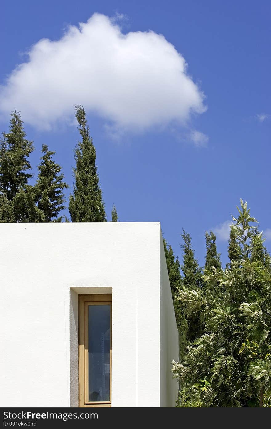 New, white building with slim window, fir trees and blue sky with one cloud. New, white building with slim window, fir trees and blue sky with one cloud
