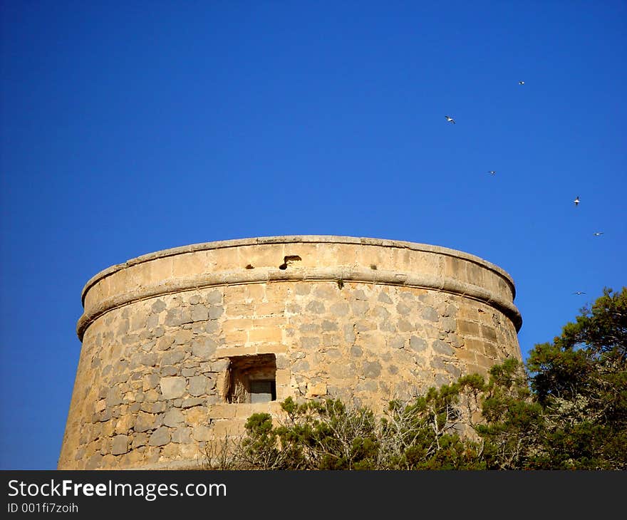 Old spanish Leadinglight Tower with seagulls in a blue sky. Old spanish Leadinglight Tower with seagulls in a blue sky.