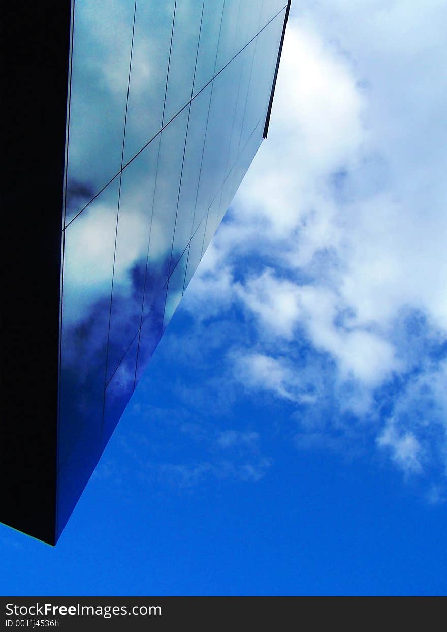 Black wall reflecting a blue sky with clouds. Black wall reflecting a blue sky with clouds