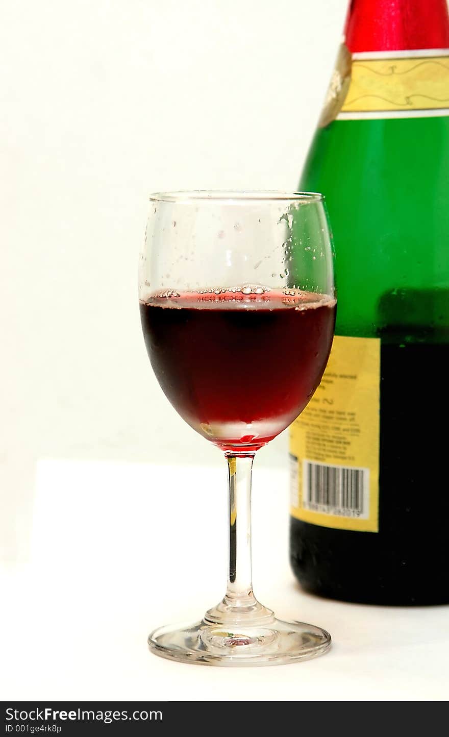 Glass of red wine and part of the bottle. Glass of red wine and part of the bottle