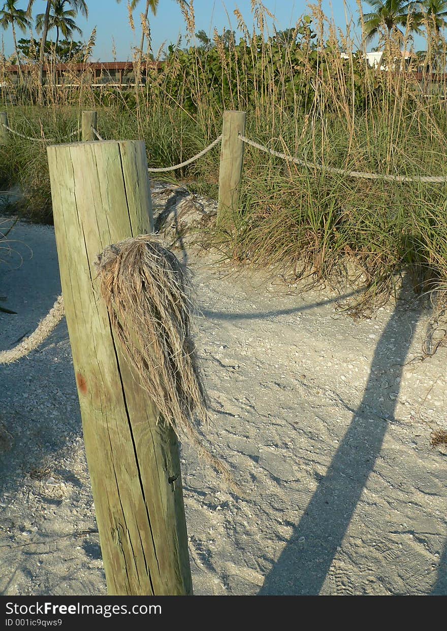 Fence post on beach path to motel