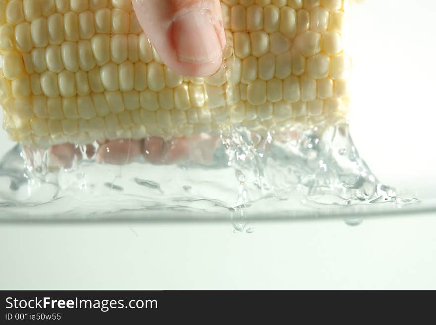 Hand lifting corn on the cob out of water. Hand lifting corn on the cob out of water