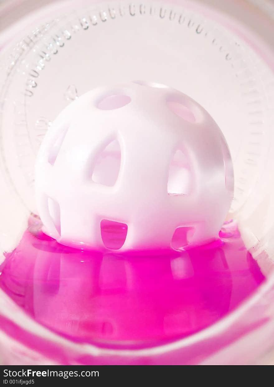 Plastic ball floating in pink liquid. Plastic ball floating in pink liquid