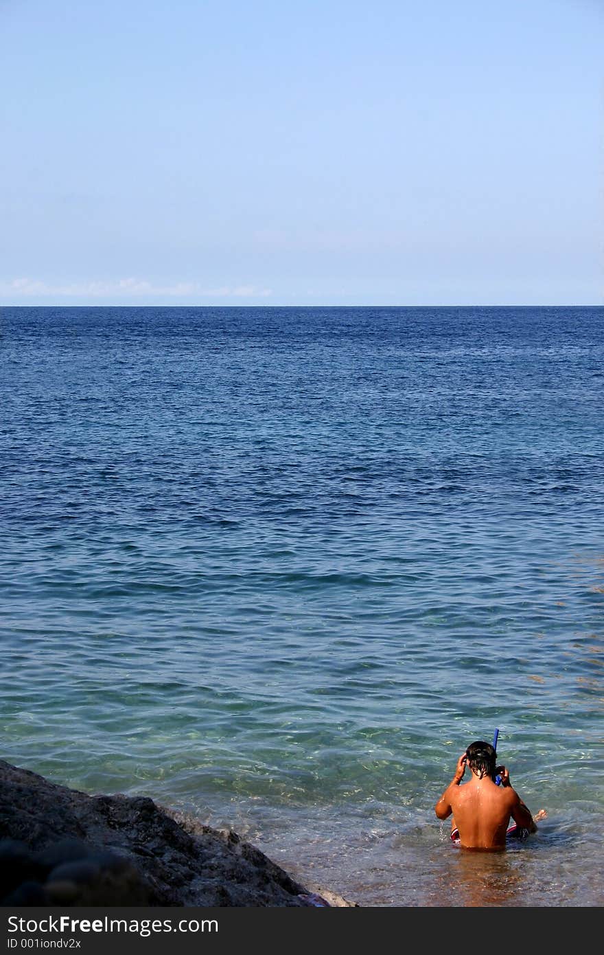 Young man ready to go snorkeling in the blue sea