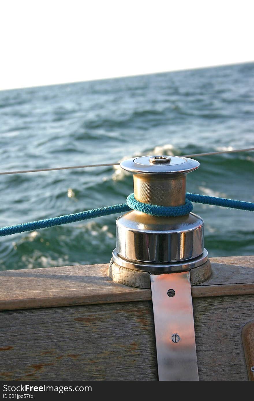 Capstan on wooden deck. A rope is tied around capstan