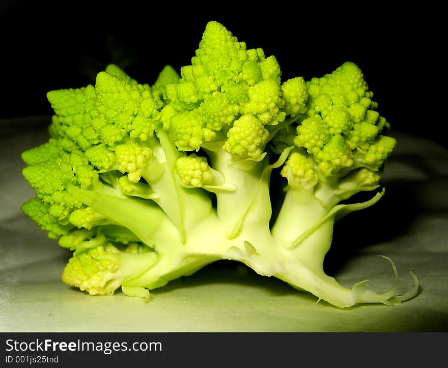 Part of fresh green cauliflower lying in the darkness