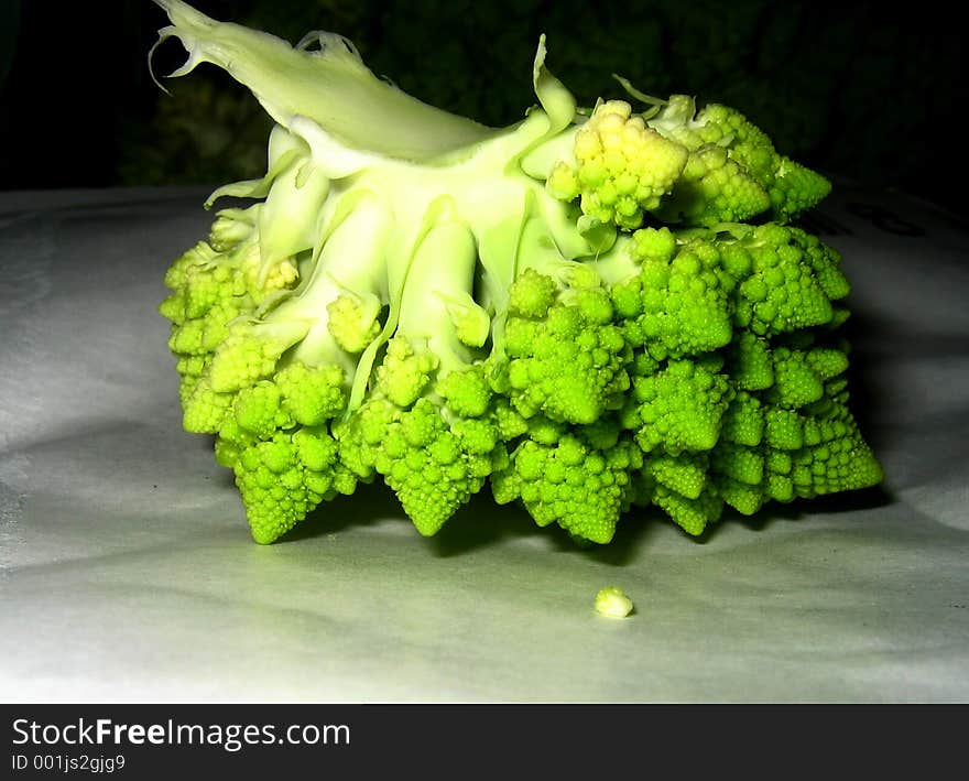 Part of fresh green cauliflower lying in the darkness