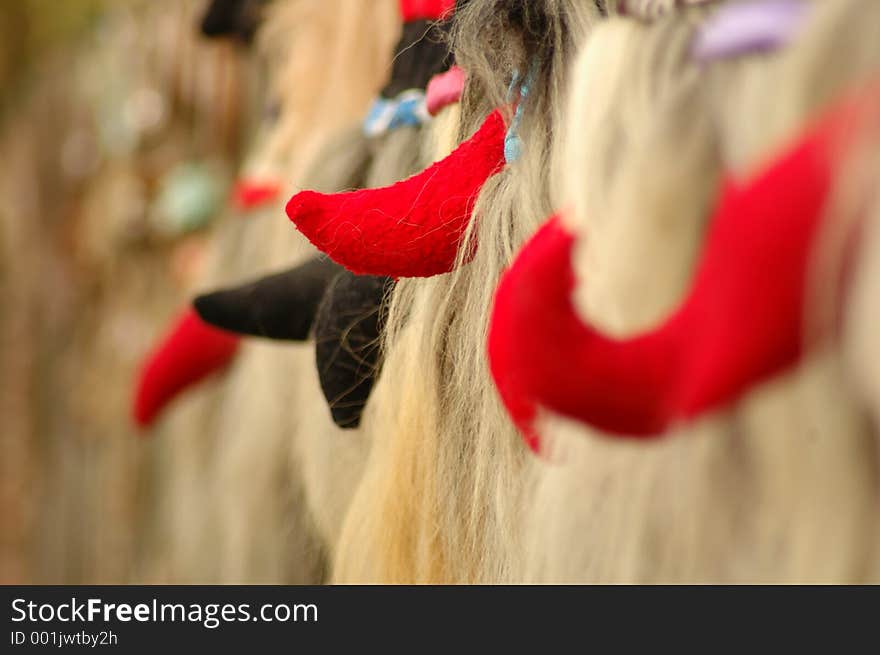 Hand-made masks hanging in a row. Focus on middle mask. Hand-made masks hanging in a row. Focus on middle mask.