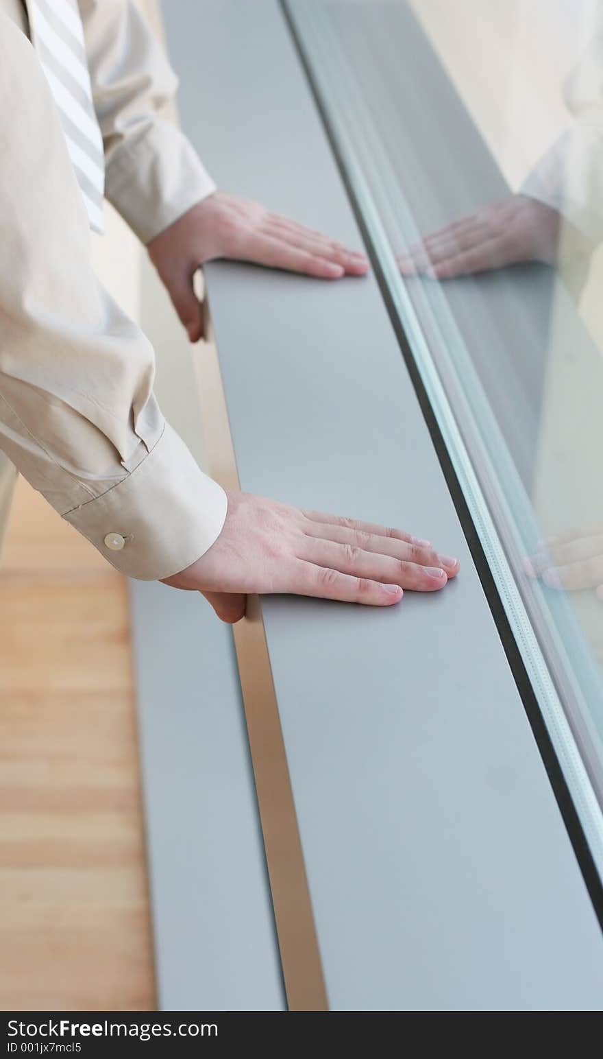 Businessman rests hands on ledge. Businessman rests hands on ledge