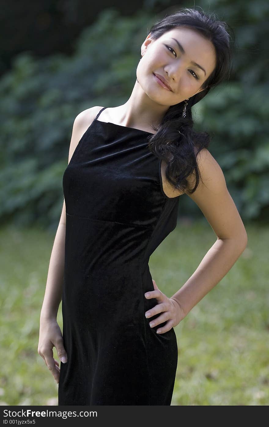 A beautiful chinese model in a black evening gown posing outside. A beautiful chinese model in a black evening gown posing outside