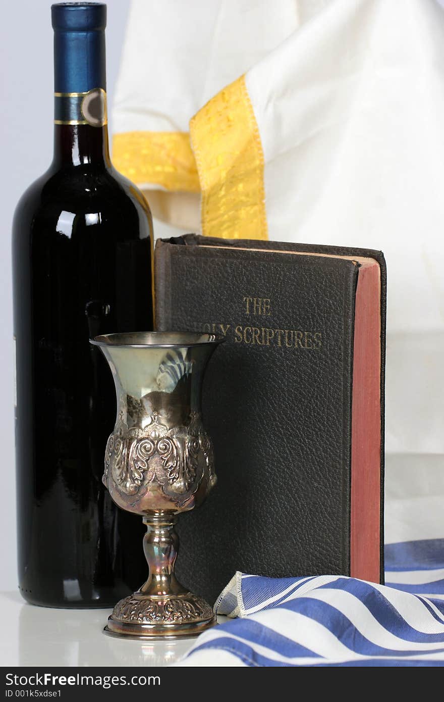 Holy Scriptures standing with Talid behind it a Kaddish cup and a bottle of red wine. Holy Scriptures standing with Talid behind it a Kaddish cup and a bottle of red wine