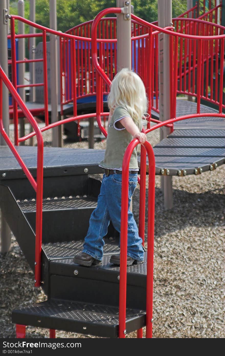 Little girl exploring play area in park,hoping to make a friend. Little girl exploring play area in park,hoping to make a friend