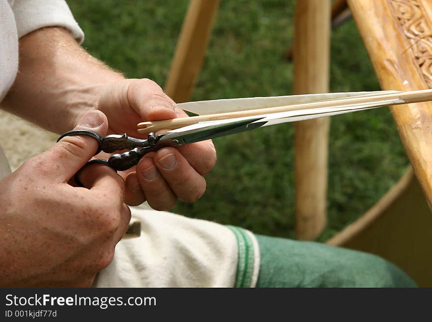 Picture of man making an arrow for shooting hes bow. Picture of man making an arrow for shooting hes bow.