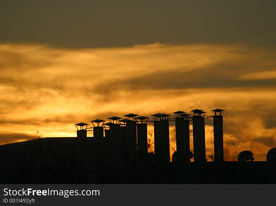 Vent stacks silhouetted against a sunset. Vent stacks silhouetted against a sunset.