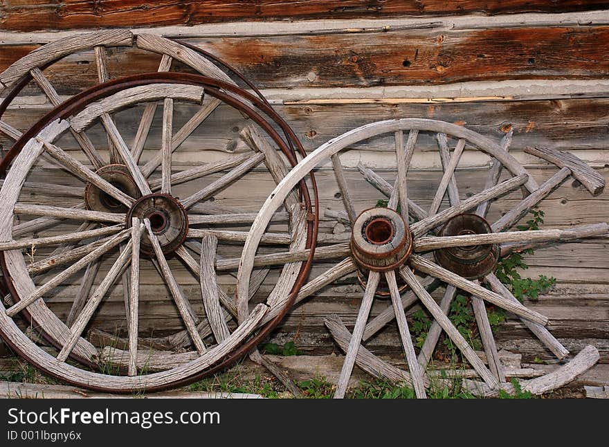 Broken wagon wheels leaning against a wall