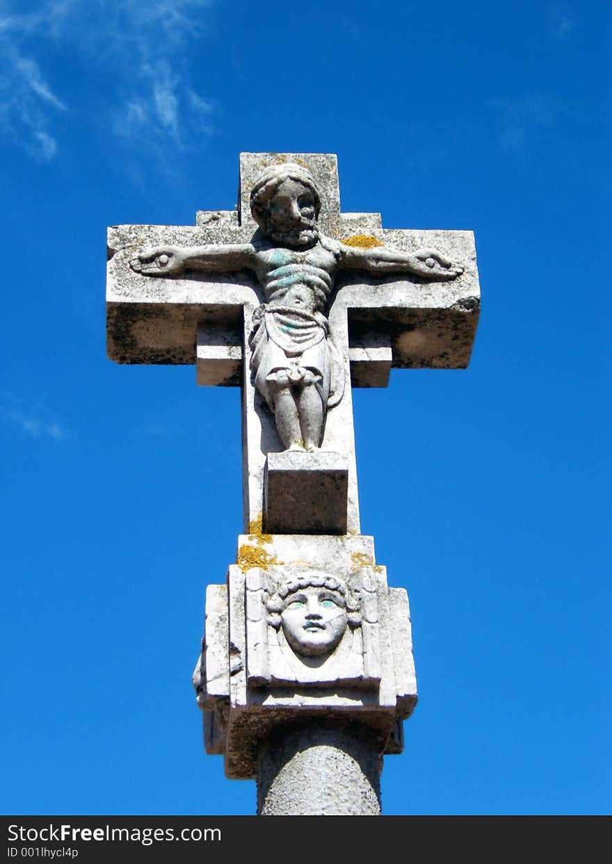 This is a religious symbol, a stone cross with a christ sculptured. This is a religious symbol, a stone cross with a christ sculptured