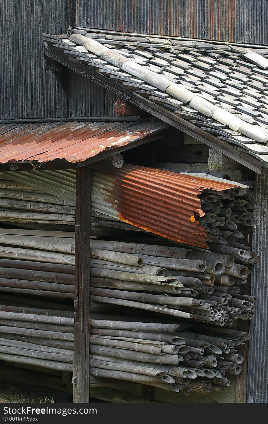 An old dilapidated Japanese shed with a rusted roof and a supply of old bamboo. An old dilapidated Japanese shed with a rusted roof and a supply of old bamboo.