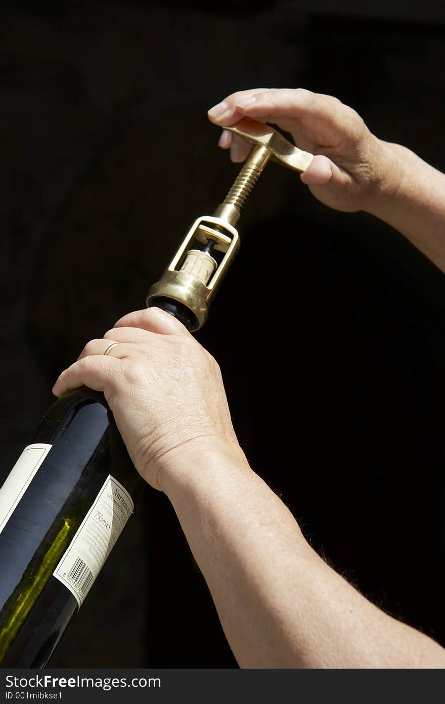 Hand uncorking a wine bottle