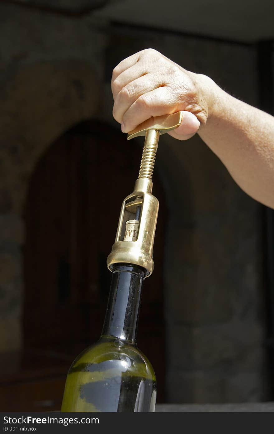 Hand uncorking a wine bottle