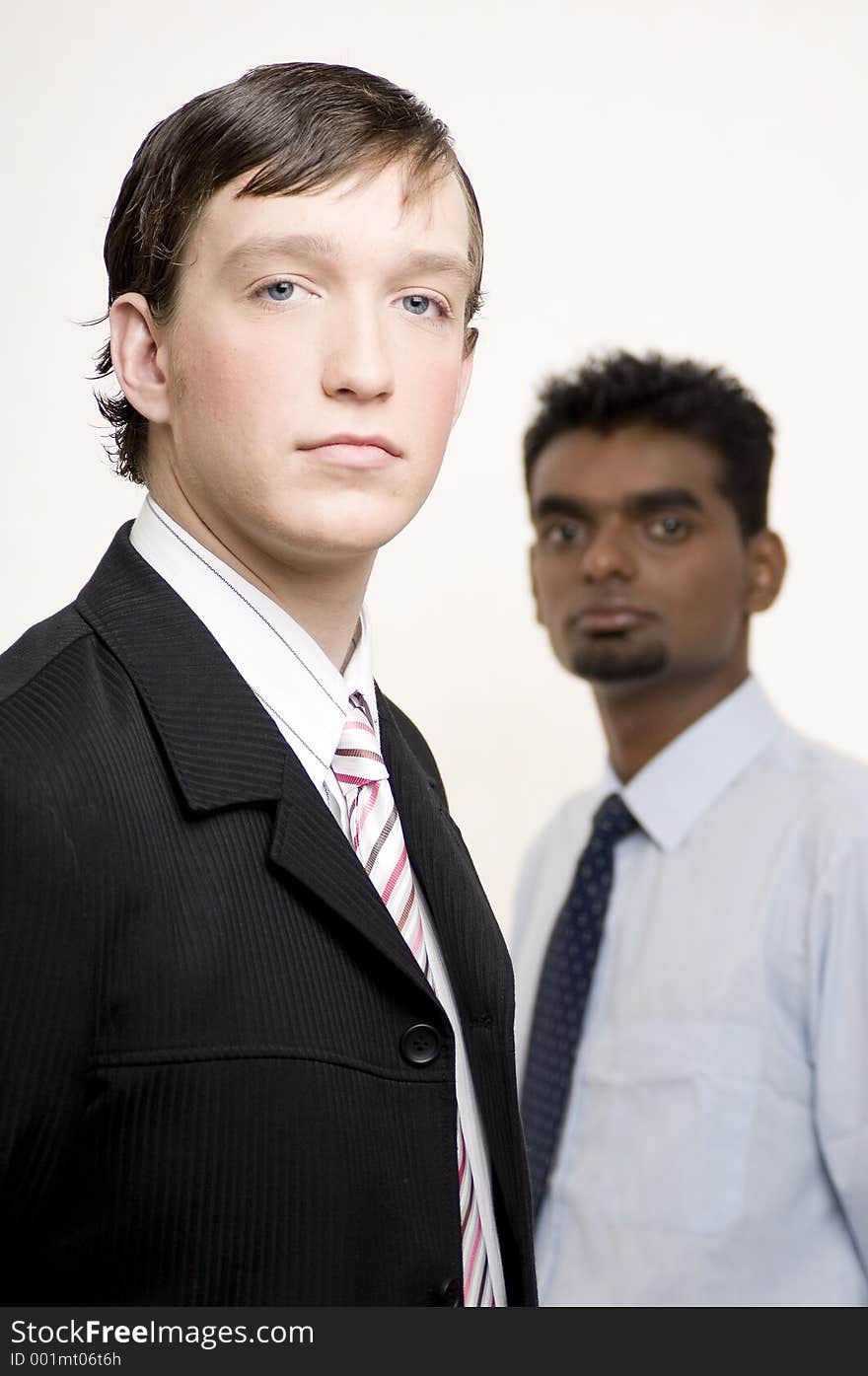 A smart caucasian businessman in a suit (in focus) with another businessman behind (out of focus). A smart caucasian businessman in a suit (in focus) with another businessman behind (out of focus)