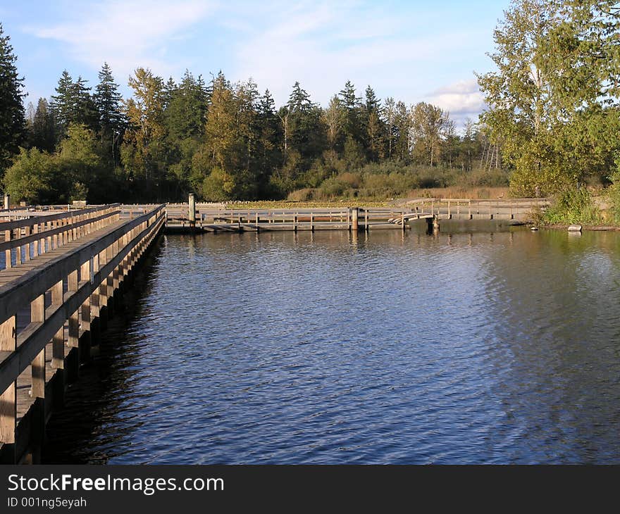 A wood boardwalk leading out over Five Mile Lake in Federal Way, Washington. A wood boardwalk leading out over Five Mile Lake in Federal Way, Washington.