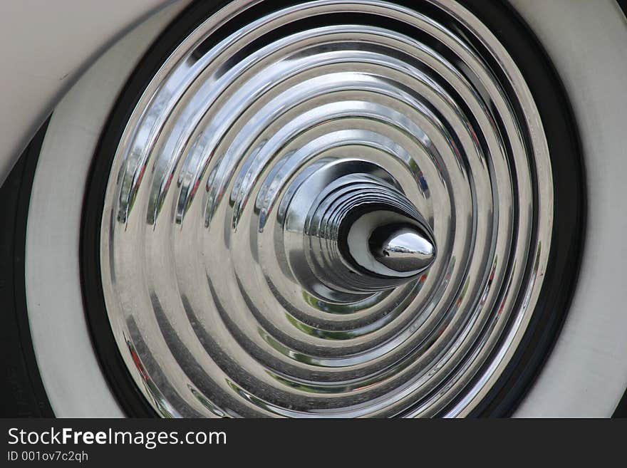 Silver rippled hubcap of old sports car. Silver rippled hubcap of old sports car.