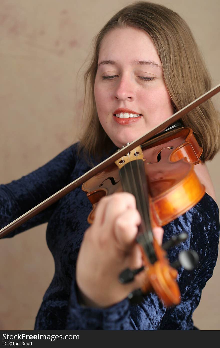 A pretty young woman playing the violin. A pretty young woman playing the violin.