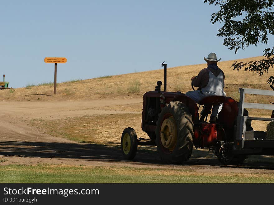 Afarmer driving a tractor. Afarmer driving a tractor