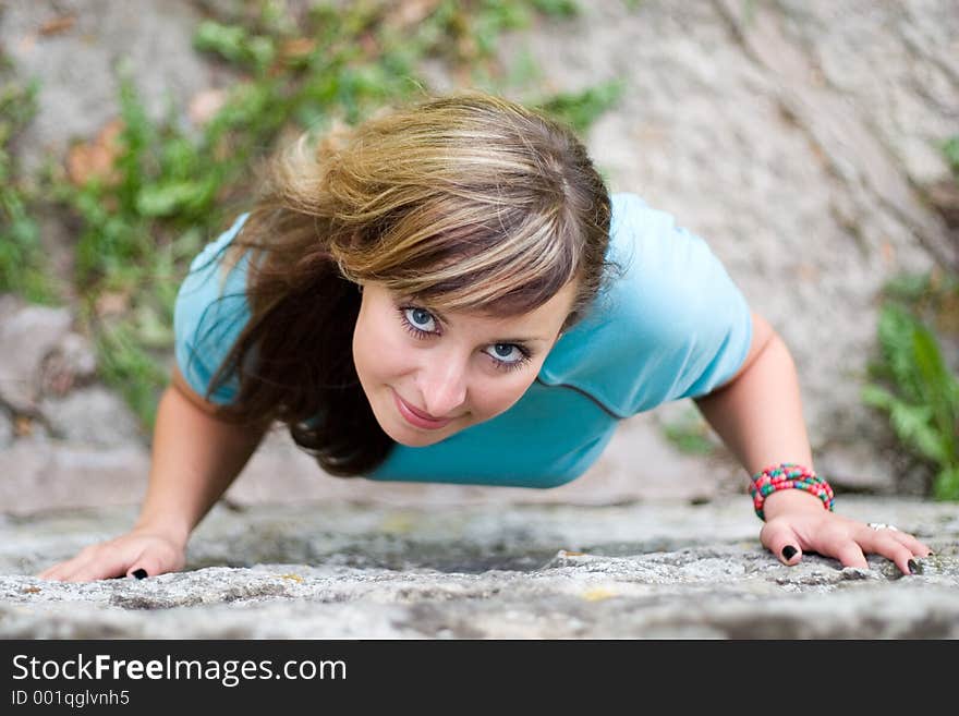 Young beautiful girl standing near brick wall and looking above