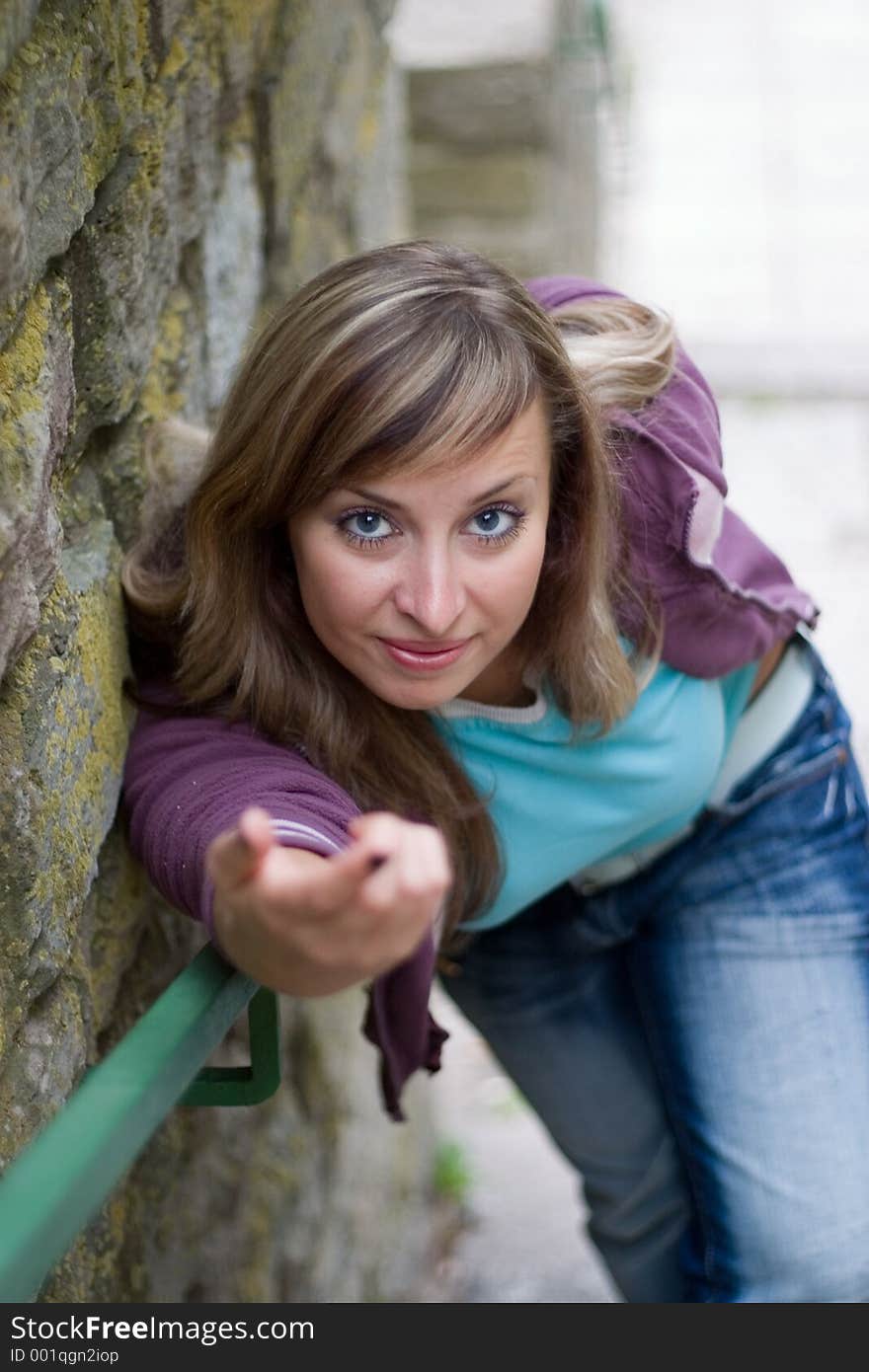 Young beautiful girl standing near brick wall, shallow DOF. Young beautiful girl standing near brick wall, shallow DOF