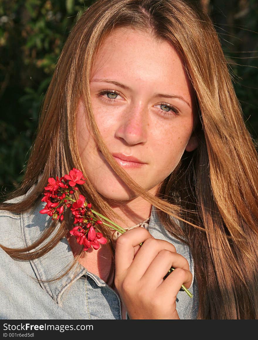 A beautiful, glamorous teen girl holding a flower. A beautiful, glamorous teen girl holding a flower.