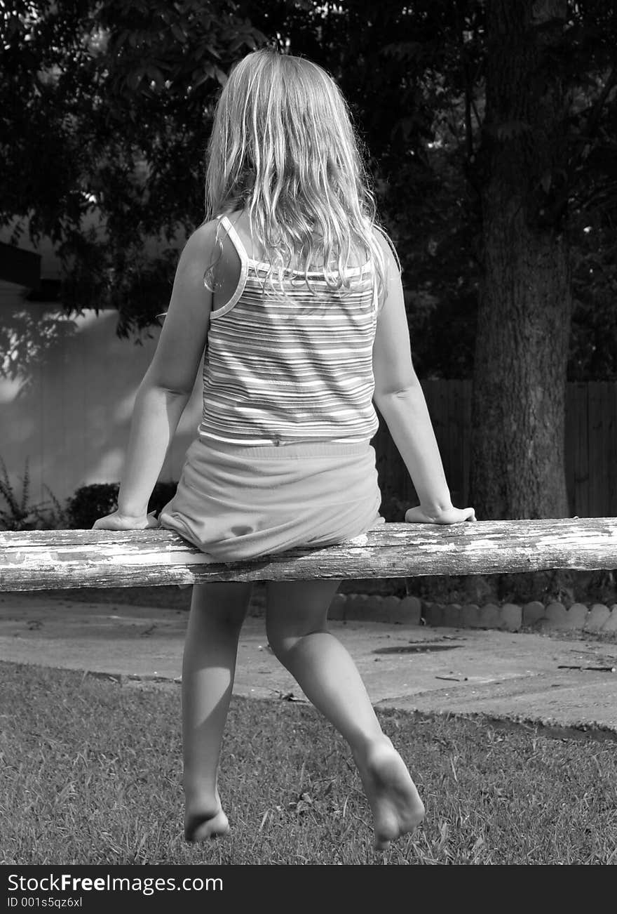 Black and white image of a young girl on a split rail fence. Black and white image of a young girl on a split rail fence.