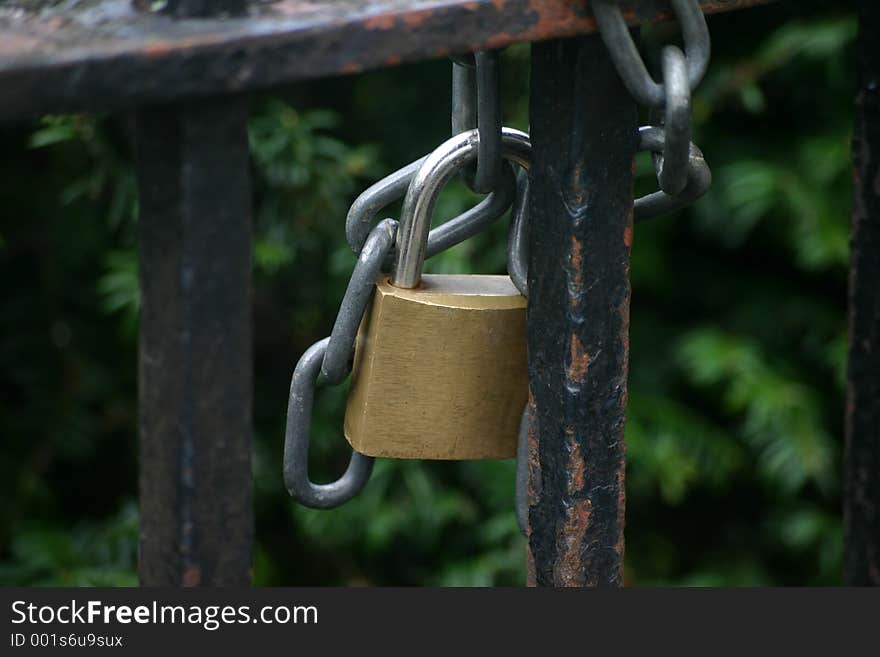 Steel and Brass Padlock and Steel Chain on Old Black Iron Gate. Steel and Brass Padlock and Steel Chain on Old Black Iron Gate