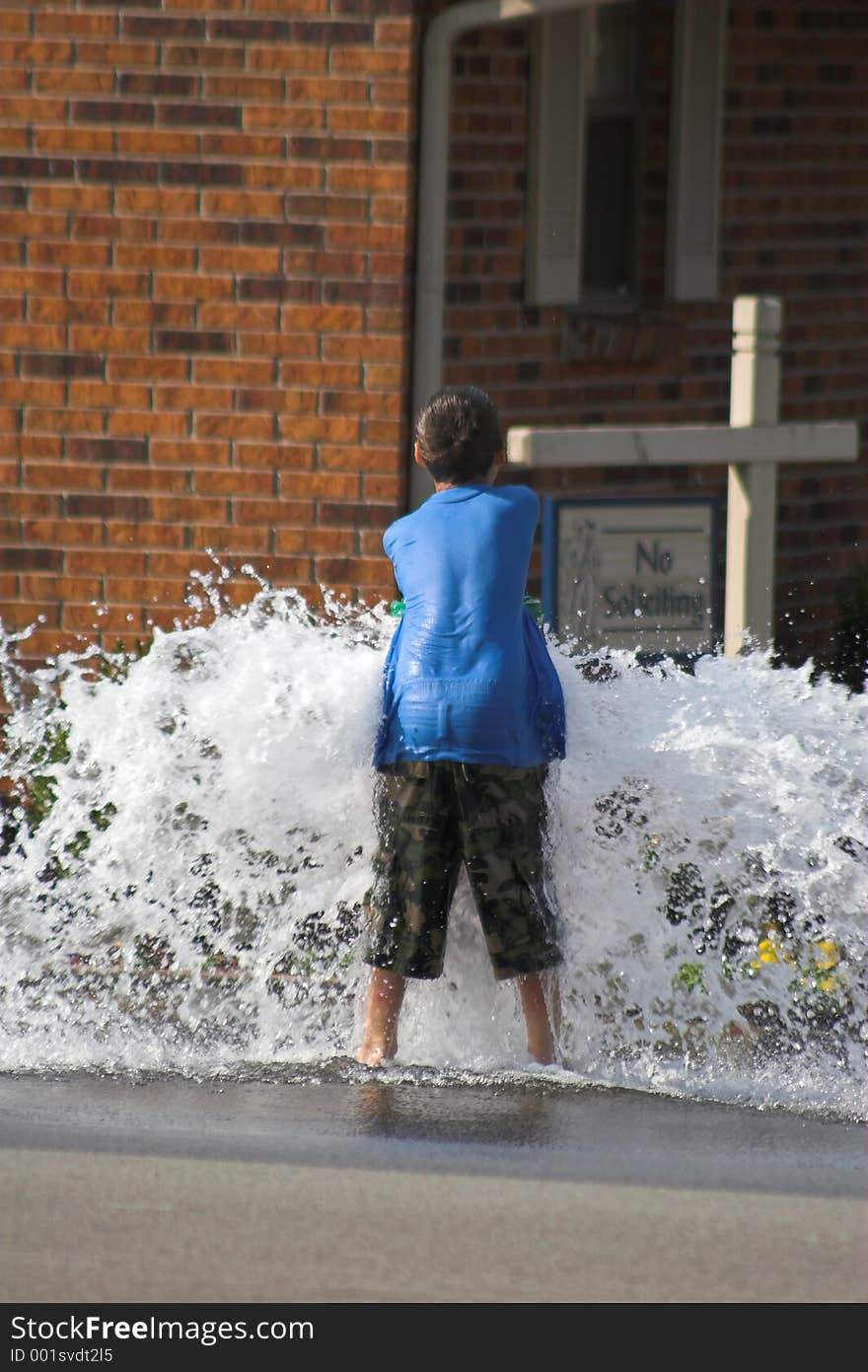 Boy playing in water from fire hydrant. Boy playing in water from fire hydrant