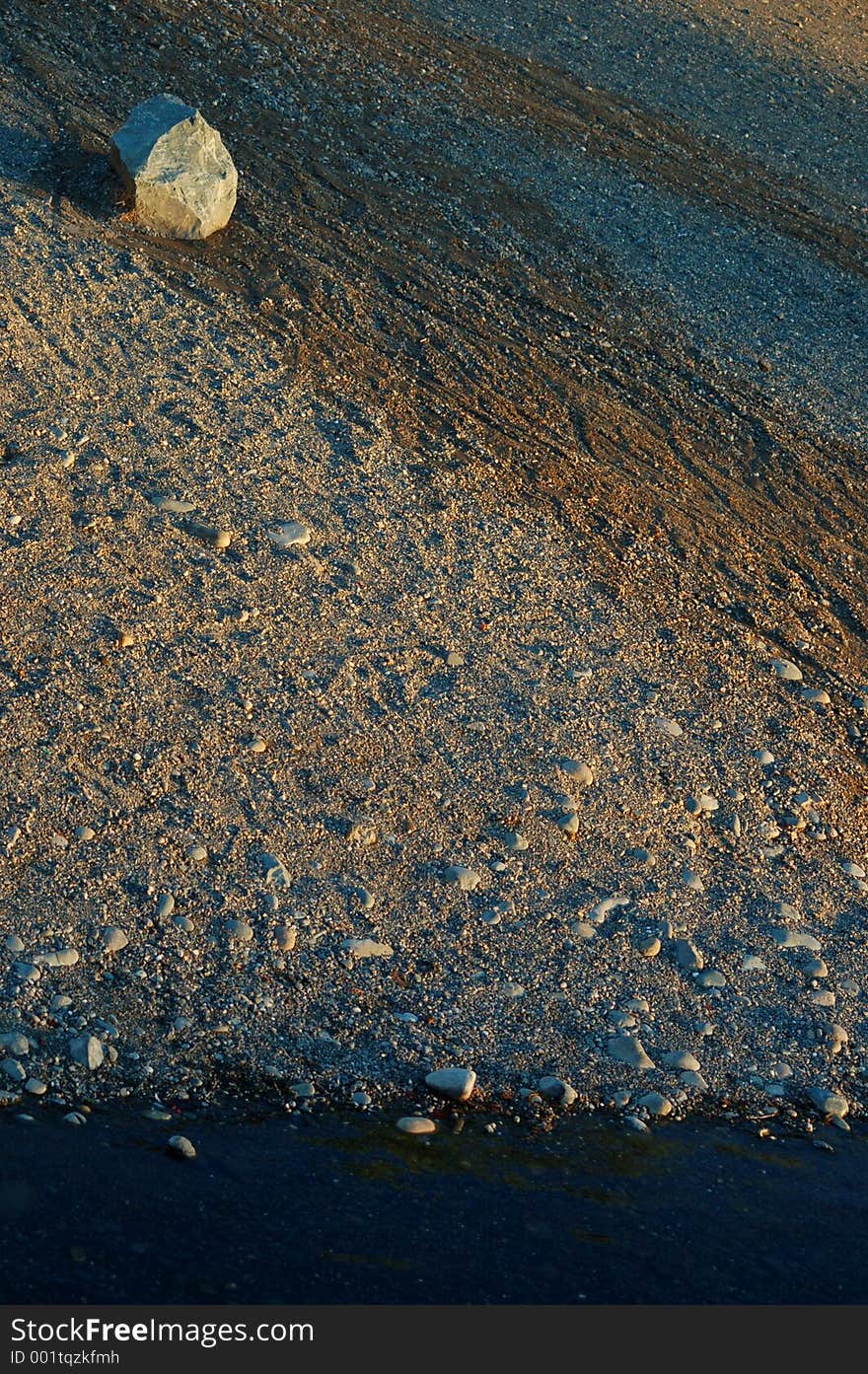 A rocky shoreline or a river with gravel and rocks.