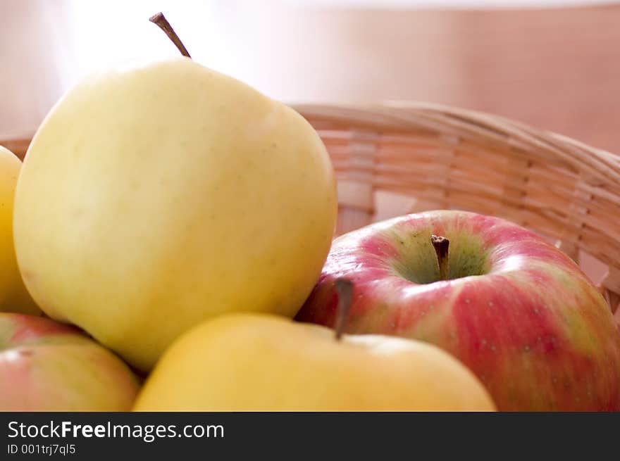 Red and yellow apples in a basket.