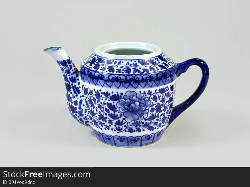 China teapot with cobalt blue handle and paintings.