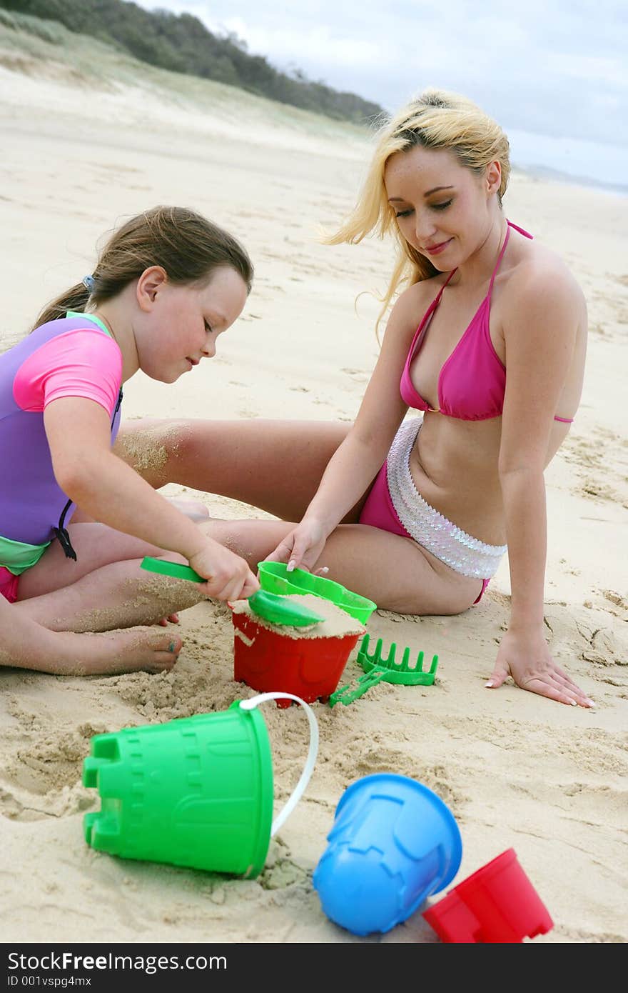 O of teen and child playing on the beach. O of teen and child playing on the beach.